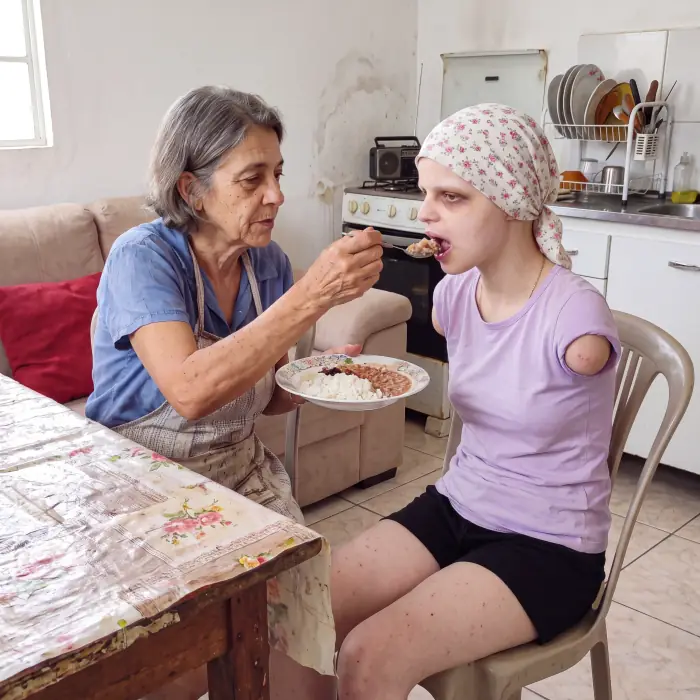 Neusa dando comida a Sophia com uma colher